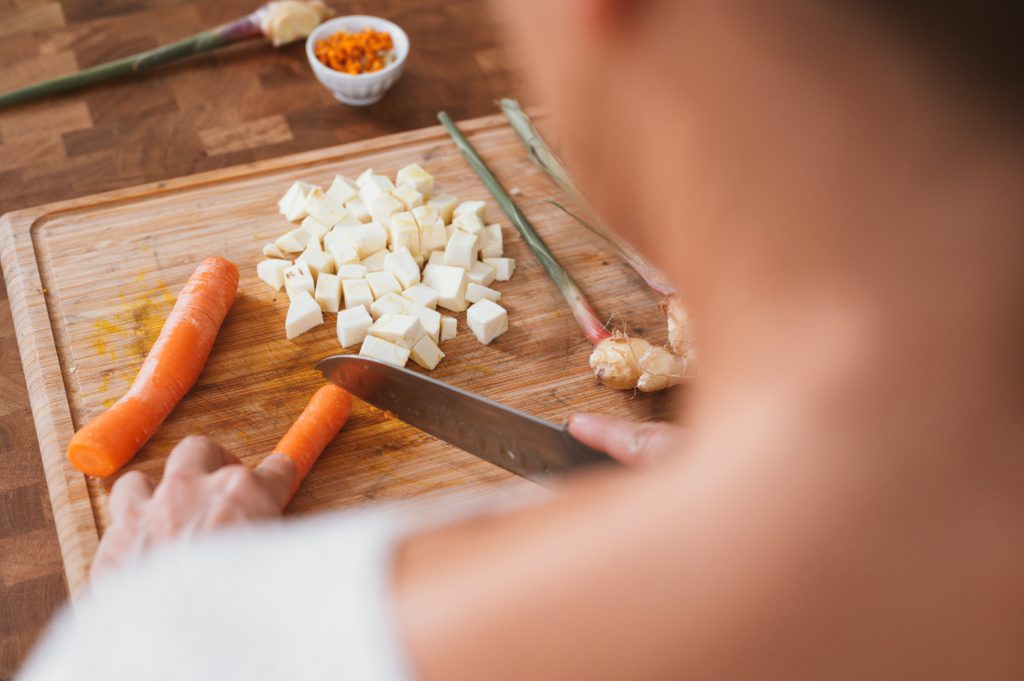 Chopping carrots and potatoes on a cutting board